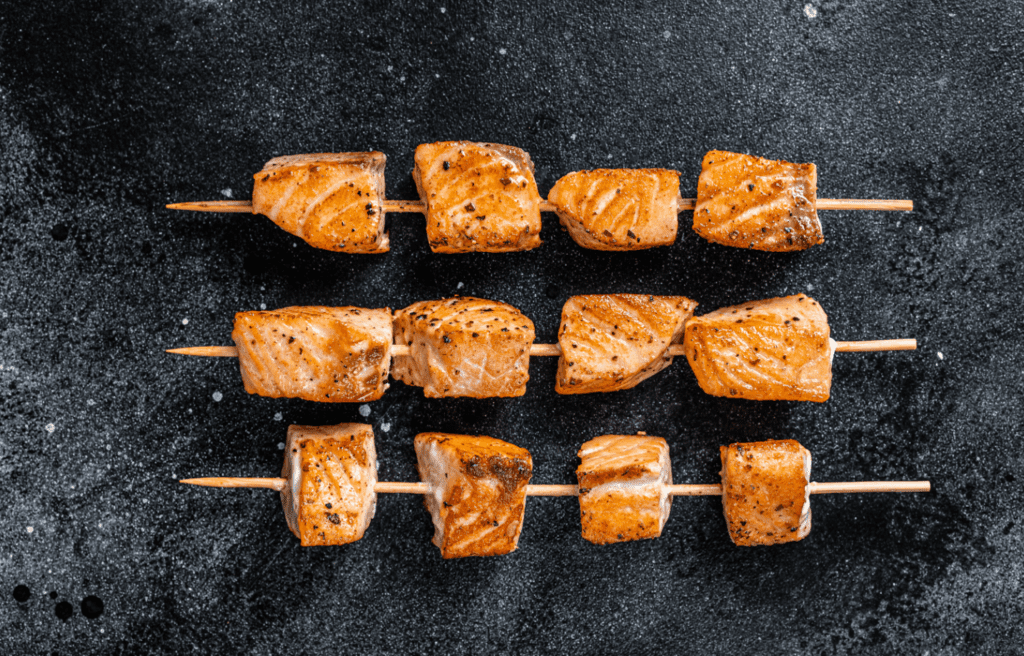 grilled-salmon-kebab-skewers-black-background