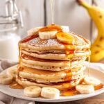 Fluffy banana pancakes topped with fresh bananas and honey